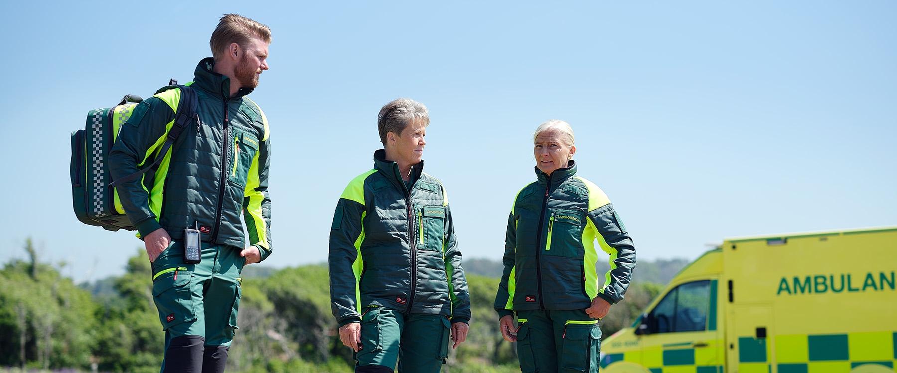 Ambulance staff wearing green work jackets