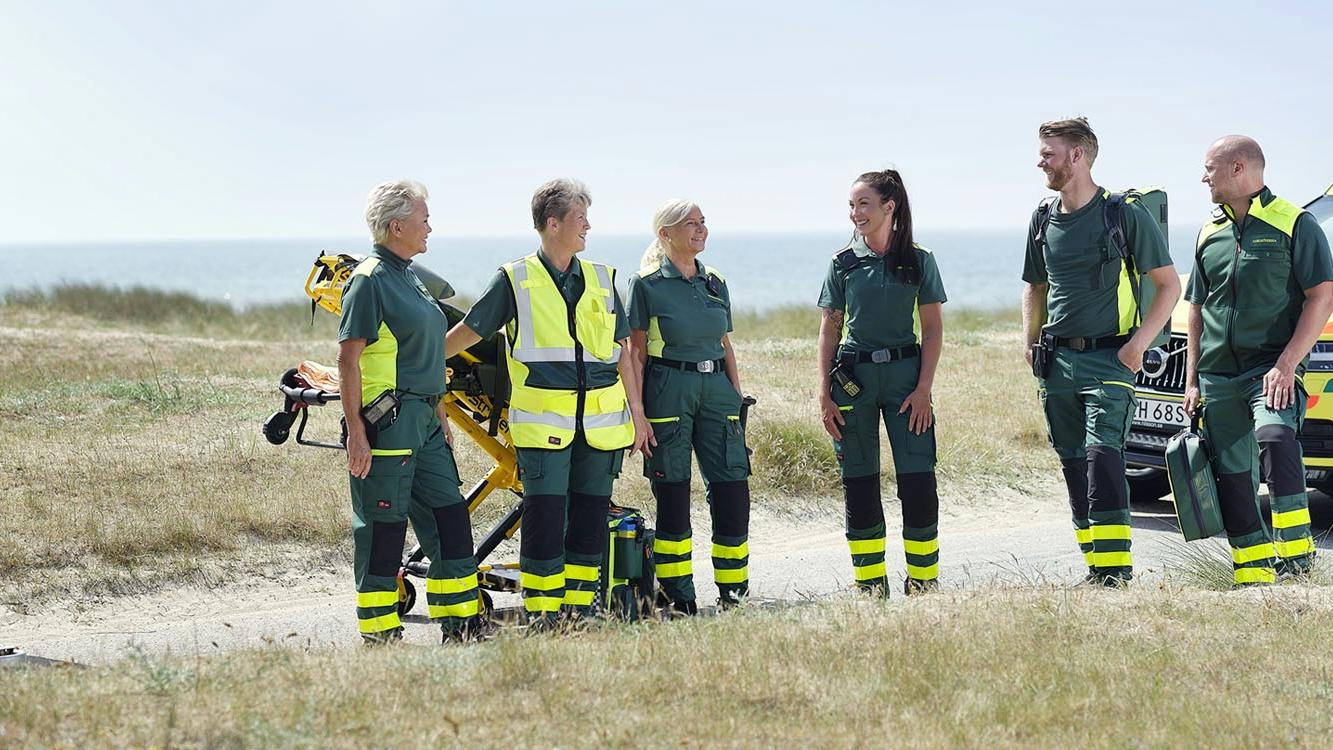 Ambulance professionals wearing green workwear